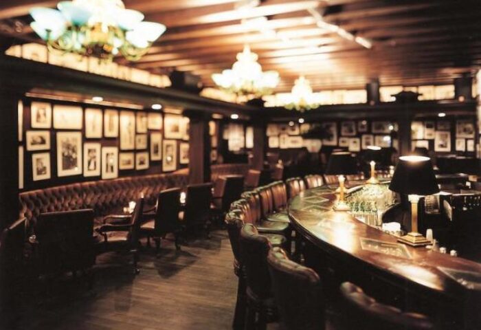 Grand Hyatt Seoul's bar, a gay-friendly hotel. Dark wood bar, leather chairs, framed photos, and chandeliers create a sophisticated ambiance.