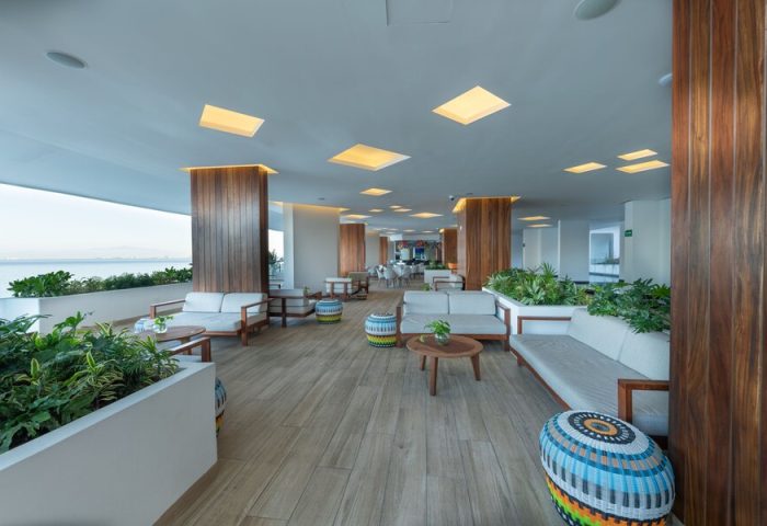 Grand Park Royal Puerto Vallarta All-Inclusive gay-friendly hotel lounge area. Stylish seating, plants, and ocean view. Perfect for gay travelers.