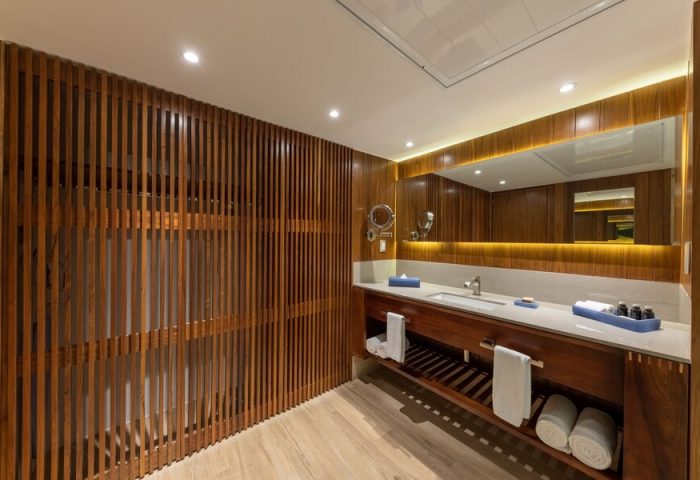 Bathroom at Grand Park Royal Puerto Vallarta All-Inclusive. Gay-friendly hotel with wooden design, large mirror, and modern sink.