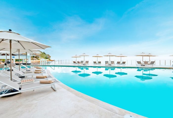 Pool view at Grand Park Royal Puerto Vallarta, an all-inclusive, gay-friendly hotel. Lounge chairs and umbrellas by the pool.