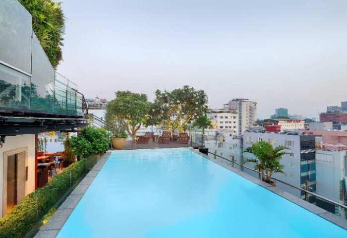 Rooftop pool at Grand Silverland Hotel, a gay-friendly hotel. City views, lounge chairs, and lush greenery create a relaxing atmosphere.