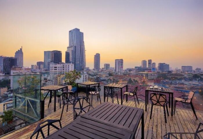 Grand Silverland Hotel's rooftop bar view. Gay-friendly hotel with city skyline, tables, and chairs. Perfect for gay travel and relaxation.