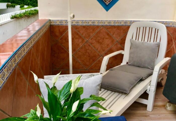 Guadalupe Cozy Inns gay-friendly hotel room. Relaxing terrace with chair, table, and plant. Ideal for gay men travelers' comfort.