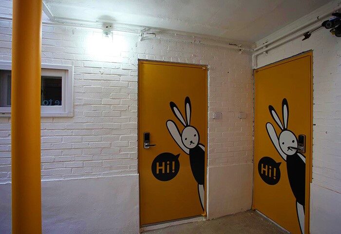 Guest House DODAMi: Two yellow doors with a bunny design. Gay-friendly hotel with unique decor for gay men travelers. Interior view.