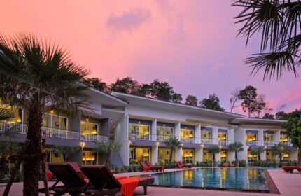 Gypsy Sea View Resort, a gay-friendly hotel. Pool, lounge chairs, and palm trees at dusk. Ideal for gay men's travel and relaxation.