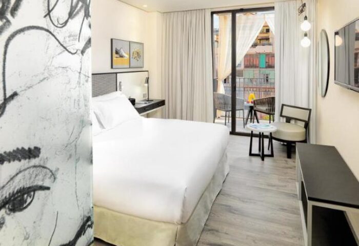 H10 Art Gallery Hotel room. Gay-friendly hotel with a balcony, desk, and queen bed. Modern art and decor. Perfect for gay travel in Barcelona.