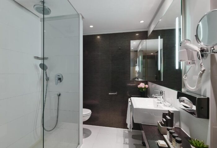 H10 Berlin Ku'damm Hotel bathroom. Modern design with shower, sink, and amenities. Gay-friendly hotel in Berlin, Germany.