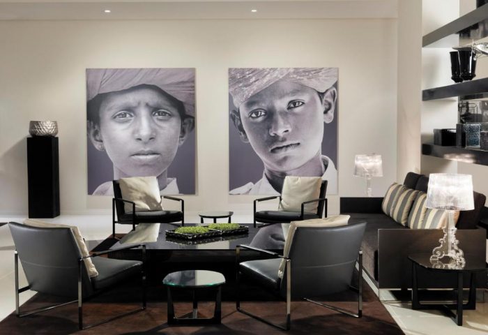 H10 Berlin Ku'damm Hotel lobby. Modern design with chairs, table, couch, lamps, and wall art. Gay-friendly hotel in Berlin, Germany.
