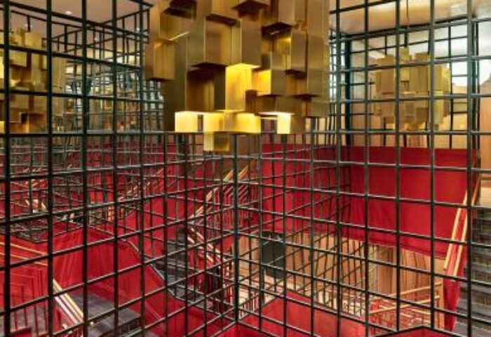 Staircase with red accents and gold geometric chandeliers at the gay-friendly H10 Metropolitan Hotel, a stylish choice for LGBT travelers.