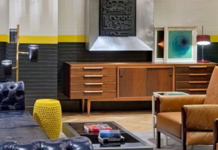 H10 Metropolitan Hotel's gay-friendly interior: Stylish mid-century modern design with leather seating, wooden cabinets, and contemporary art.