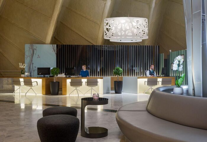 H10 Playa Meloneras Palace lobby. Gay-friendly hotel reception area with modern design, seating, and staff ready to assist guests. Luxury travel.