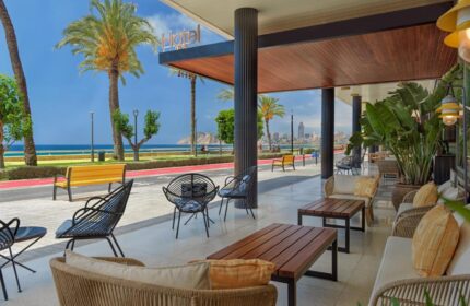 H10 Porto Poniente 4* Sup Hotel patio view. Gay-friendly hotel with ocean views, seating, and palm trees. Great for gay travel.