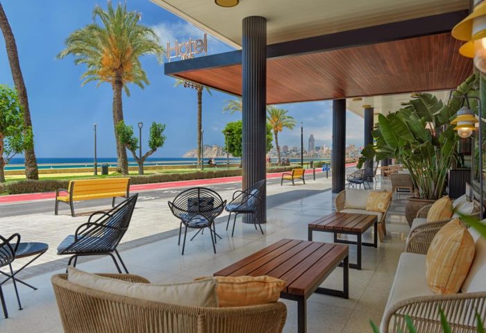 H10 Porto Poniente 4* Sup Hotel patio view. Gay-friendly hotel with ocean views, seating, and palm trees. Great for gay travel.