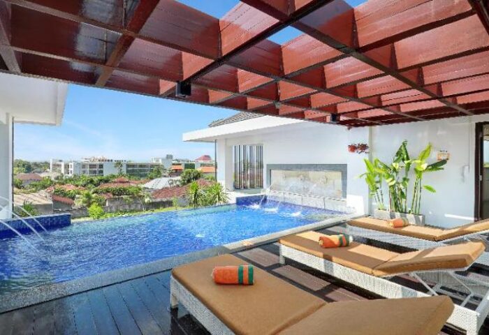 Poolside view at HARRIS Hotel Seminyak, a gay-friendly hotel. Loungers invite relaxation by the pool, perfect for a gay travel getaway.