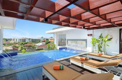 Rooftop pool at HARRIS Hotel Seminyak, a gay-friendly hotel. Loungers offer relaxation with city views. Perfect for gay men's travel in Bali.
