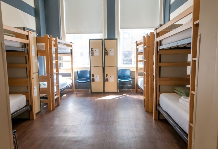 HI Chicago Hostel dorm room. Bunk beds line the walls, with lockers and chairs in between. A gay-friendly hotel for budget travel.