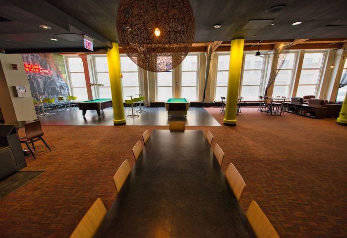 HI Chicago Hostel's common area. Gay-friendly hotel with pool tables, large windows, and a communal table. Great for gay men travel.
