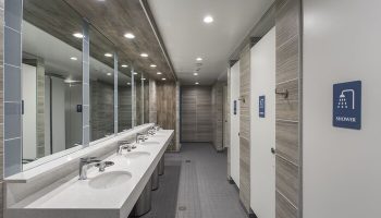 HI Los Angeles Santa Monica Hostel's bathroom. Gay-friendly hotel with modern sinks, mirrors, and shower stalls. Great for gay travel.