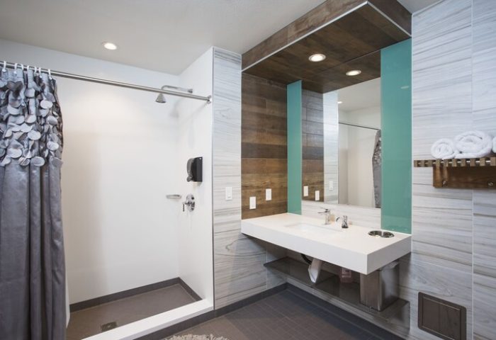 HI Los Angeles Santa Monica Hostel bathroom. Gay-friendly hotel featuring modern sink, shower, and wood accents. Great for gay travelers.