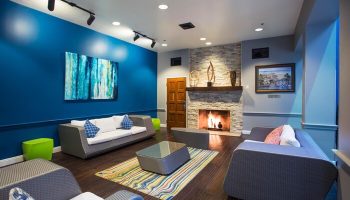 HI Los Angeles Santa Monica Hostel's gay-friendly hotel lounge. Fireplace, sofas, and colorful decor create a welcoming space for travelers.
