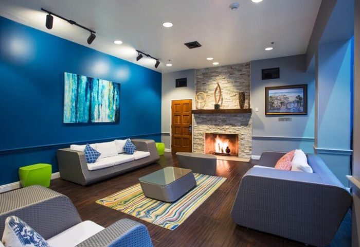HI Los Angeles Santa Monica Hostel's gay-friendly hotel lounge. Fireplace, sofas, and colorful decor create a welcoming space for travelers.