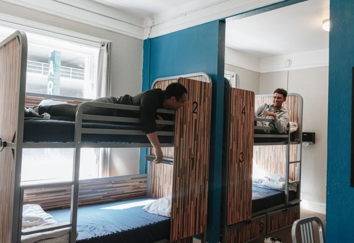 HI San Francisco Downtown Hostel dorm room with two men. Gay-friendly hotel with bunk beds, privacy panels. Travel advice for gay men.