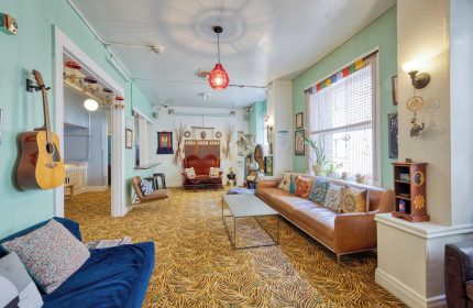 HI San Francisco Downtown Hostel's common area. A guitar hangs on the wall. Gay-friendly hotel with a social atmosphere.