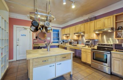 HI San Francisco Downtown Hostel kitchen. Gay-friendly hotel with stainless steel appliances, cookware, and an island. Ideal for gay travelers.