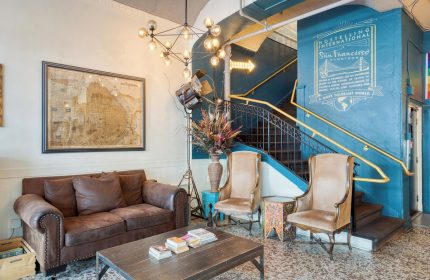 HI San Francisco Downtown Hostel lobby. Gay-friendly hotel with vintage decor, map, and staircase. Perfect for gay travel in San Francisco.