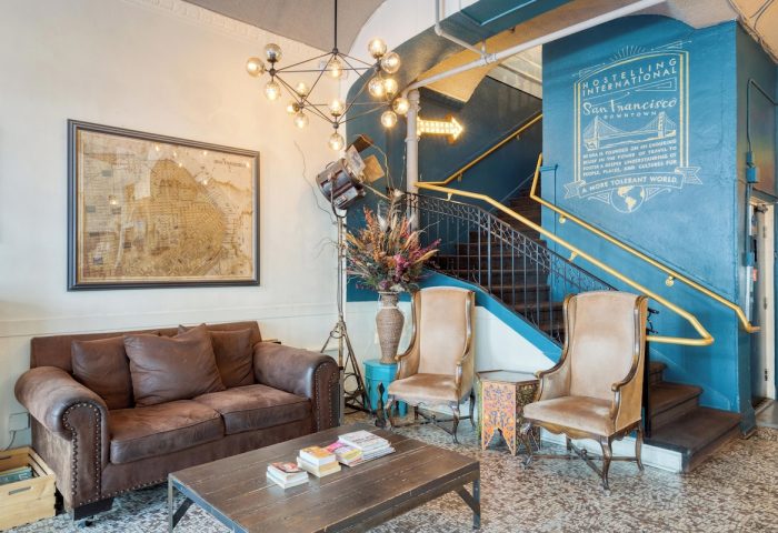 HI San Francisco Downtown Hostel lobby. Gay-friendly hotel with vintage decor, map, and staircase. Perfect for gay travel in San Francisco.