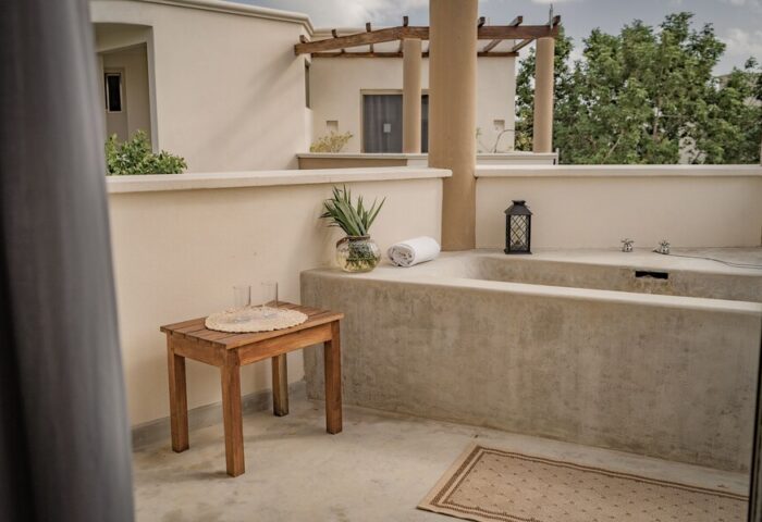 Hotel Posada 06 Tulum Adults Only gay-friendly hotel room. Outdoor terrace with bathtub, table, and tropical decor for gay travelers.