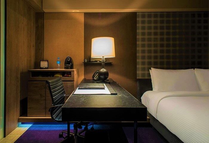HOTEL QUOTE Taipei room with desk, chair, lamp, and bed. Gay-friendly hotel in Taipei, Taiwan. Modern interior design.