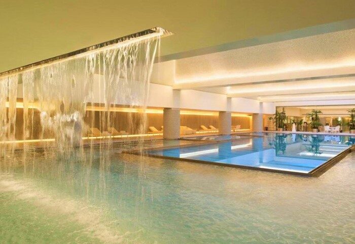HUALUXE Shanghai Twelve At Hengshan gay-friendly hotel pool. Waterfall feature, lounge chairs, and modern design for gay travelers.