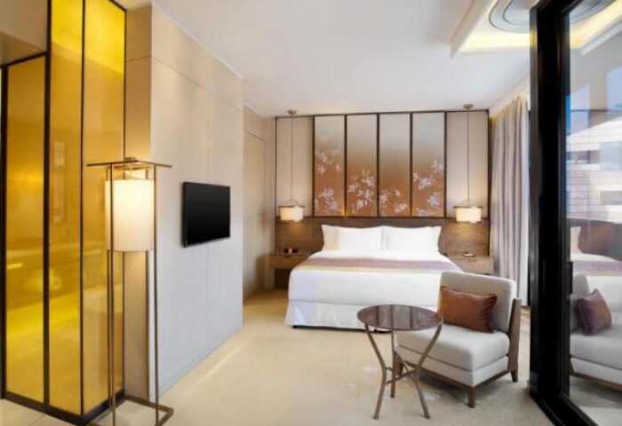 HUALUXE Shanghai Twelve At Hengshan gay-friendly hotel room. Modern design, comfortable bed, chair, and table. Luxury Shanghai hotel for gay travelers.