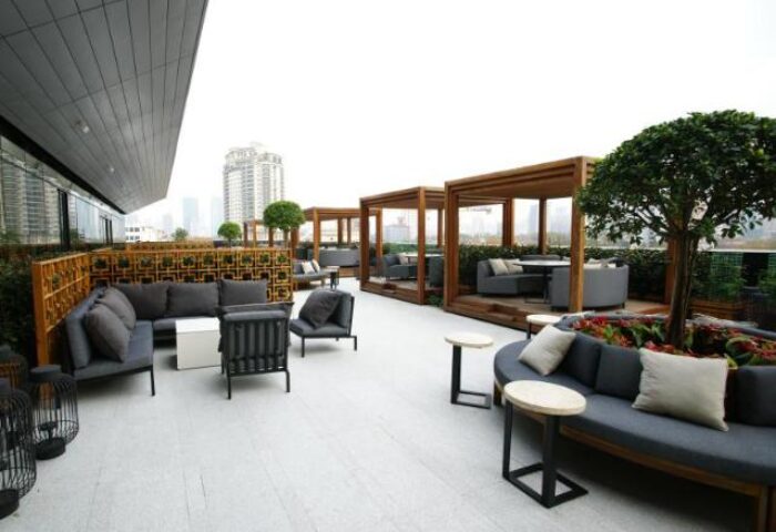 HUALUXE Shanghai Twelve At Hengshan gay-friendly hotel rooftop lounge area with sofas, chairs, tables, and city views.