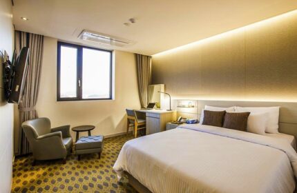 Hamilton Hotel Itaewon guest room. Gay-friendly hotel with a bed, desk, chair, and window. Modern design, comfortable for gay travelers.