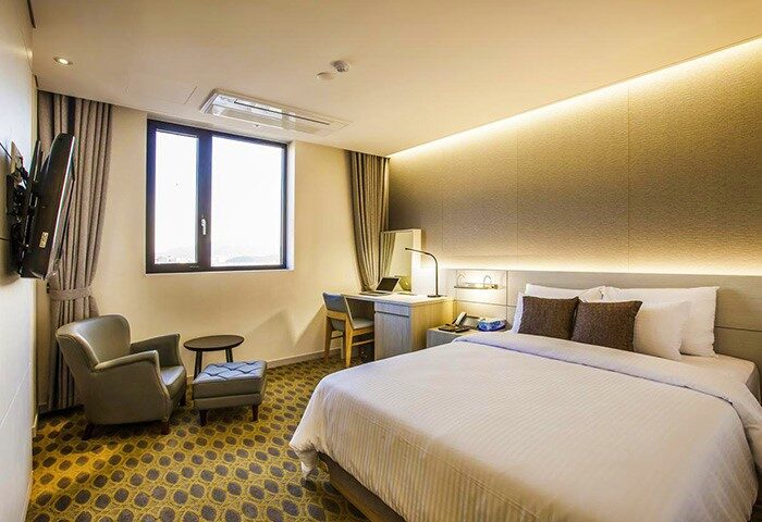 Hamilton Hotel Itaewon guest room. Gay-friendly hotel with a bed, desk, chair, and window. Modern design, comfortable for gay travelers.