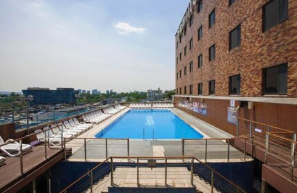 Rooftop pool at Hamilton Hotel Itaewon, a gay-friendly hotel. Lounge chairs surround the pool with city views. Perfect for gay travel.