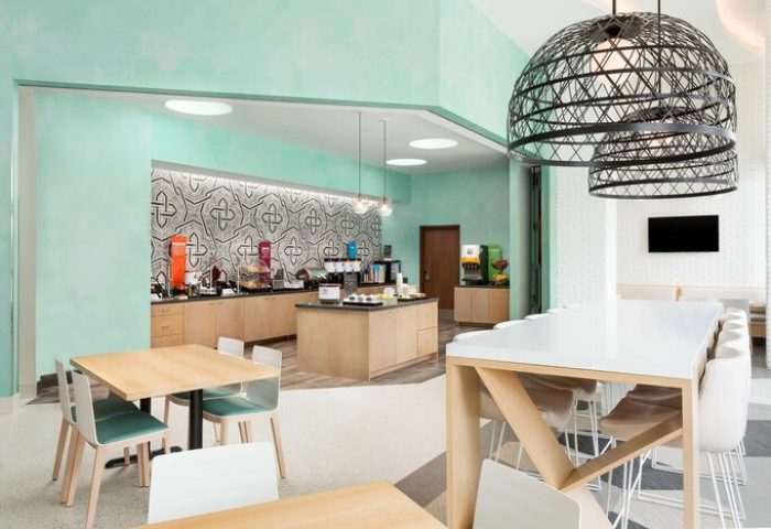 Hampton Inn & Suites Santa Monica breakfast area. Gay-friendly hotel with modern decor, tables, and a breakfast bar. Perfect for gay travelers.