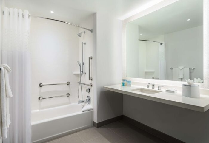Hampton Inn & Suites Santa Monica bathroom. Gay-friendly hotel with accessible tub, shower, grab bars, and sink. Modern, clean design.