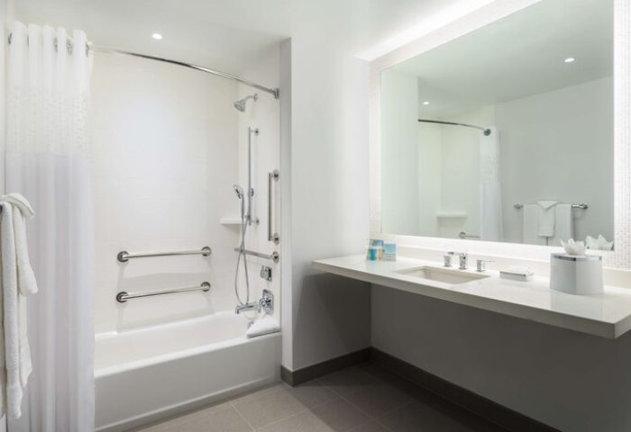 Hampton Inn & Suites Santa Monica bathroom. Gay-friendly hotel with accessible tub, shower, grab bars, and sink. Modern, clean design.