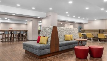 Hampton Inn & Suites by Hilton Toronto Downtown lobby seating area. Gay-friendly hotel with modern design and comfortable spaces.