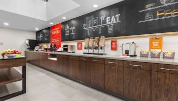 Breakfast bar at Hampton Inn & Suites by Hilton Toronto Downtown, a gay-friendly hotel. Cereal, waffles, and dietary needs info available.