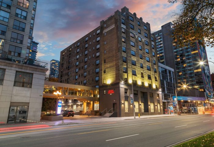 Exterior of Hampton Inn & Suites by Hilton Toronto Downtown, a gay-friendly hotel for gay men, at dusk.