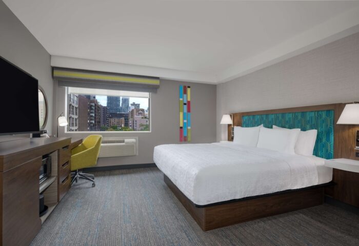Hampton Inn & Suites by Hilton Toronto Downtown room. King bed, desk, TV, and city view. Gay-friendly hotel.