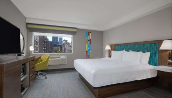 Hampton Inn & Suites by Hilton Toronto Downtown room. King bed, desk, TV, and city view. Gay-friendly hotel.