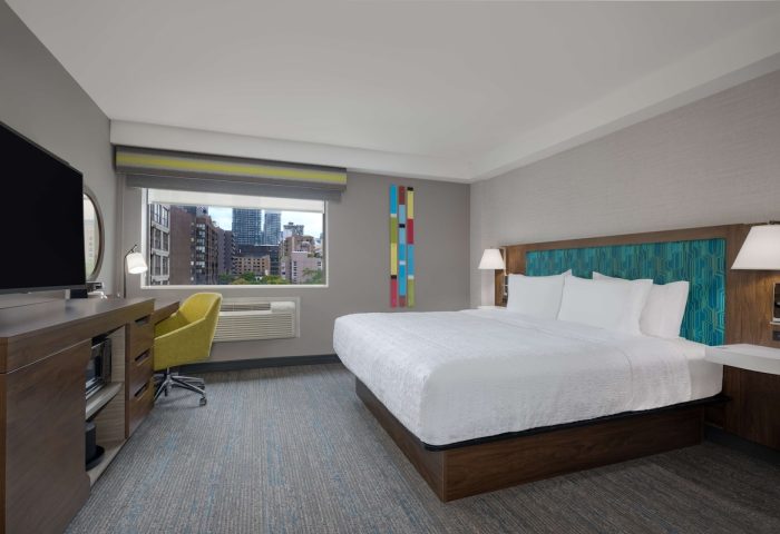 Hampton Inn & Suites by Hilton Toronto Downtown room. King bed, desk, TV, and city view. Gay-friendly hotel.