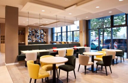 Hampton by Hilton Berlin City East Side Gallery's dining area. Gay-friendly, pet-friendly hotel with tables, chairs, and a large window.
