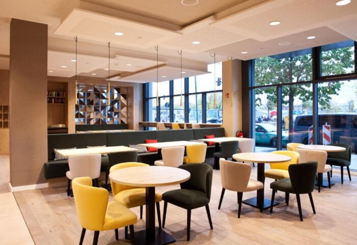 Hampton by Hilton Berlin City East Side Gallery's dining area. Gay-friendly, pet-friendly hotel with tables, chairs, and a large window.