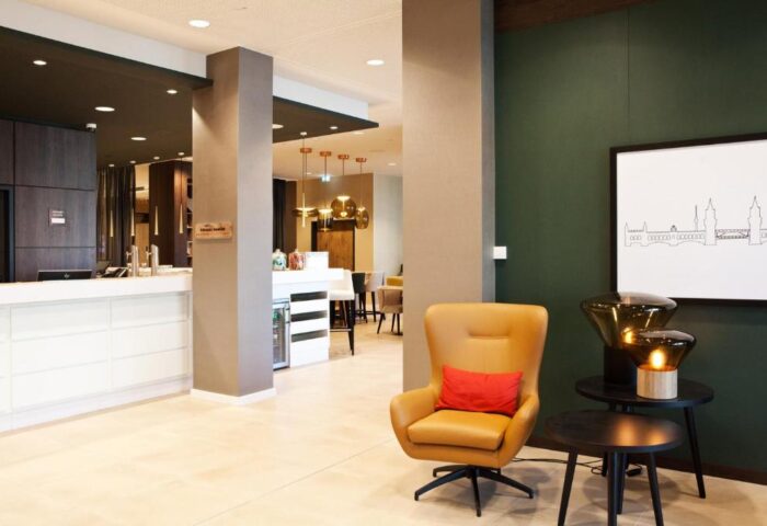 Hampton by Hilton Berlin City East Side Gallery lobby. Gay-friendly, pet-friendly hotel interior. Modern design, comfortable seating.
